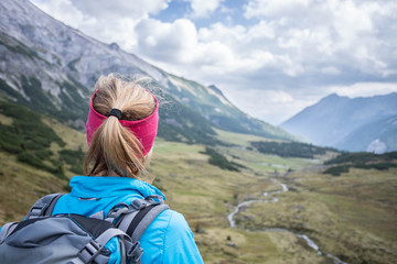 Junge blonde Frau in den Bergen, Blick in die Ferne, Abenteuer