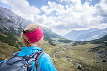 Junge blonde Frau in den Bergen, Blick in die Ferne, Abenteuer