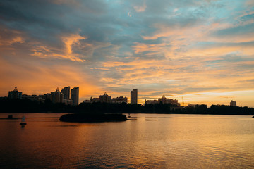 View of the city center midtown silhouette from the river at color sunset. text place
