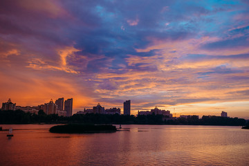 View of the city center midtown silhouette from the river at color sunset. text place