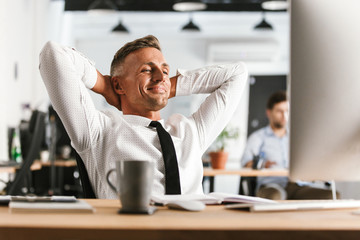 Happy business man sitting in office working with computer have a rest.