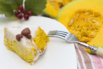 Piece of pumpkin homemade cheesecake with white cream. Thanksgiving day food.