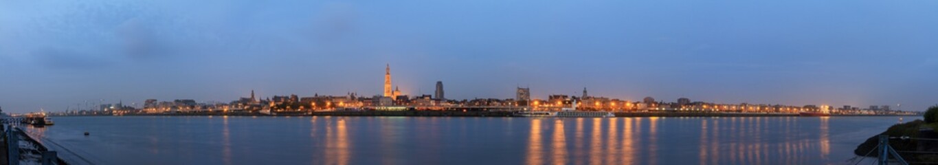 Fototapeta na wymiar Beautiful cityscape panorama of the skyline of Antwerp, Belgium, during the blue hour seen from the shore of the river Scheldt