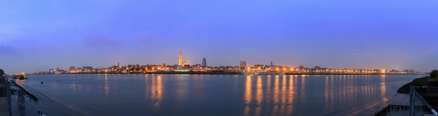 Foto op Plexiglas Prachtig stadsgezicht panorama van de skyline van Antwerpen, België, tijdens het blauwe uur gezien vanaf de oever van de rivier de Schelde © dennisvdwater