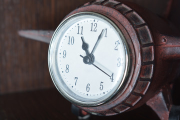 Naklejka premium a wooden clock-plane of a dark-colored tree stands on a wooden shelf