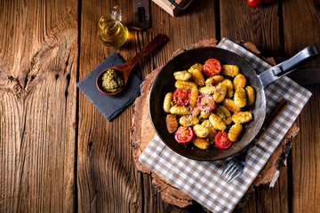 gnocchi baked with green pesto, cherry tomatoes and parmesan