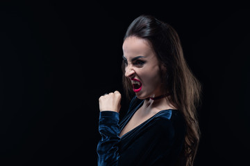 dreadful woman showing vampire teeth isolated on black