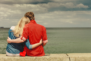 Fototapeta premium Couple sitting hugged on sea shore