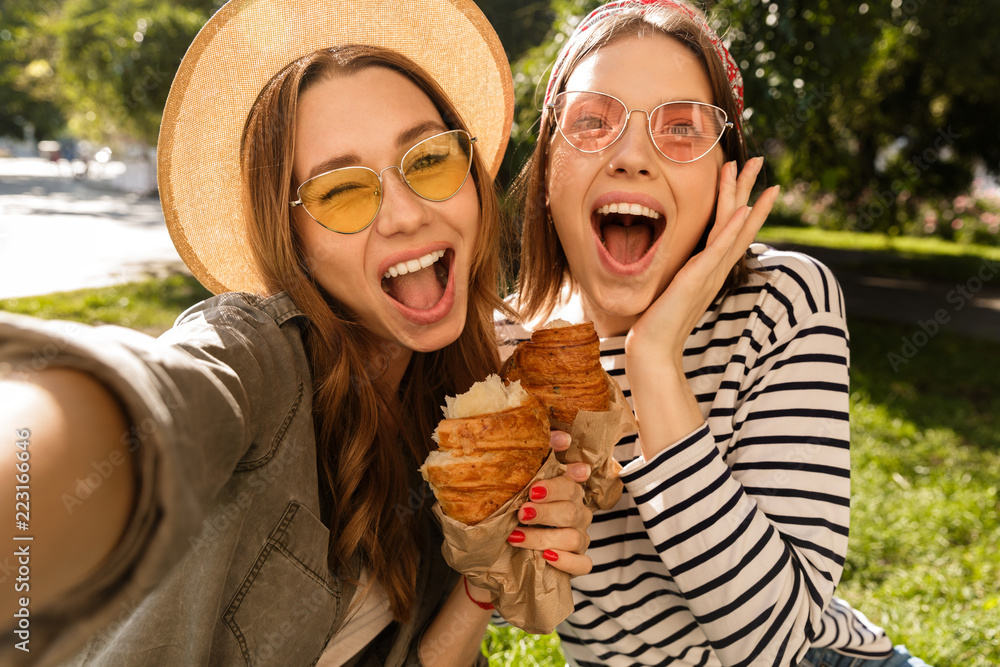 Wall mural Two laughing young girls friends having fun at the park