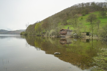 Obraz premium a view of pooley bridge boat house with a green hill background at ullswater lake in lake district national park united kingdom