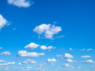 many little puffy clouds in blue sky in sunny day