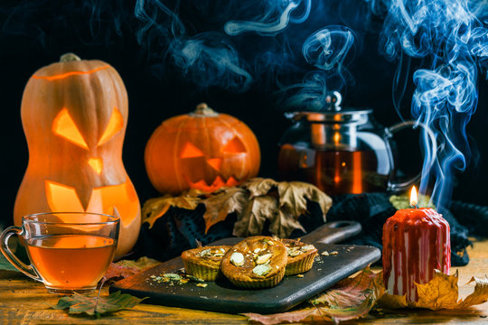 Halloween photo of table with pumpkin, biscuit, burning candle