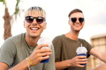 two guys drink cocktails on a tropical beach