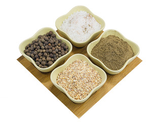 set bowl pepper black pepper garlic ground sea coriander in green ceramic cups on a wooden tray on isolated background