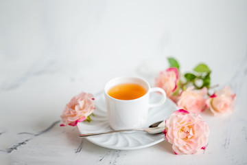 cup of tea with roses on a light background