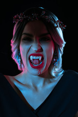 vampire woman showing vampire teeth isolated on black