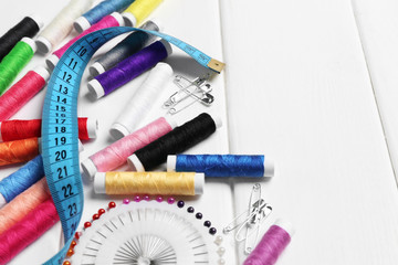 coils of colorful threads and sewing accessories on a white table