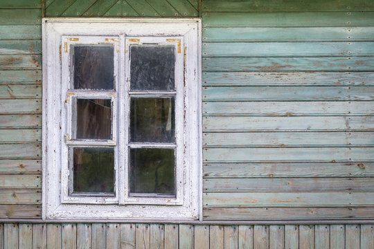 The old window of old wooden house. Background of wooden walls.