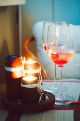 Two glass glasses with champagne and lighted candles. Evening romantic atmosphere. Vertical photography.