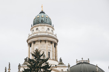 French Cathedral or Franzoesischer Dom in Berlin, Germany. Decorated Christmas tree near by. Celebrating Christmas or New Year.