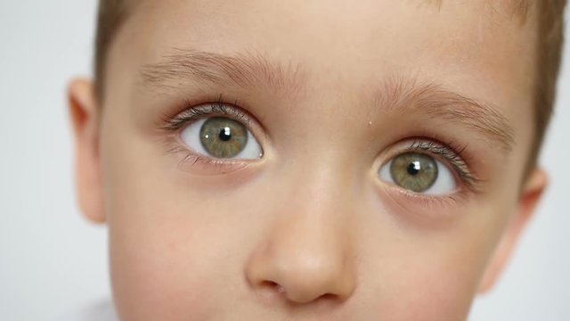 Close-up: the eyes of a child. The boy looks thoughtfully
