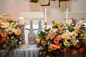 The table of the newlyweds is decorated with flowers, candles and fabrics. Concept of a wedding celebration, party, celebration of lovers, decor.