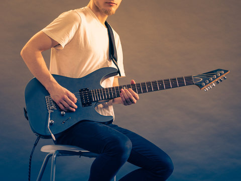 Young man playing electric guitar