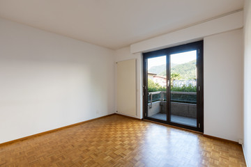 Empty room with window and parquet