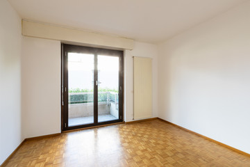 Empty room with window and parquet