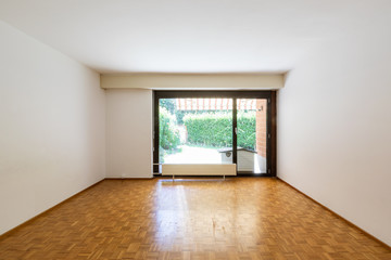 Empty room with window and parquet