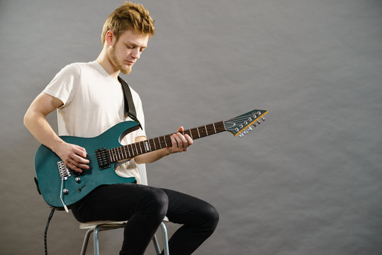 Young man playing electric guitar