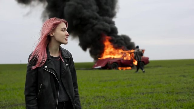 Young beautiful girl on the background of an exploding car, goth, emo girl