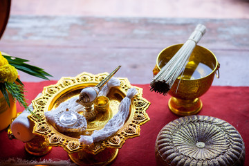 holy thread  roll on gold tray with pedestal. amulet in buddhist religion ceremony. image for...