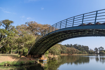 Ibirapuera's bridge with trees in the background and a big lake in the ground, in São Paulo. City, tourism, peaceful place, parks, is the concept