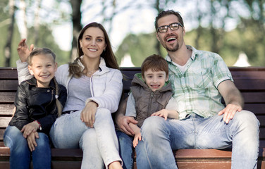 portrait of a happy family sitting on a Park bench