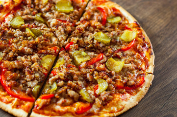 Pizza with Mozzarella cheese, minced meat and vegetables. Italian pizza on wooden background.