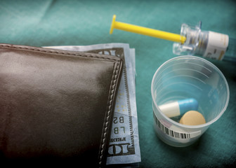 Wallet with dollar next to medicines, concept of copayment health