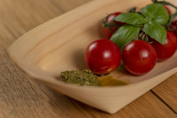 tomatoes and basil on wooden table served on bamboo boats