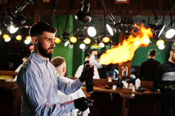 Handsome bearded man at the barbershop, barber at work with fire show.