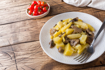 Fried potatoes with mushrooms and onions. Wooden table Copy sapce