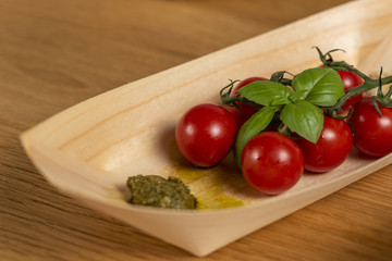 cherry tomatoes and basil on bamboo boat bowl