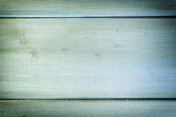 The wall of the boards is light green. Photo with wood texture.