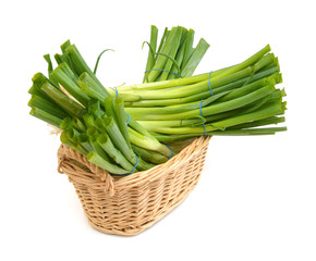 fresh green onions in basket on a white background