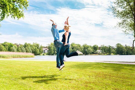 Young Modern Couple Giving Hi Five To Eachother In The Park