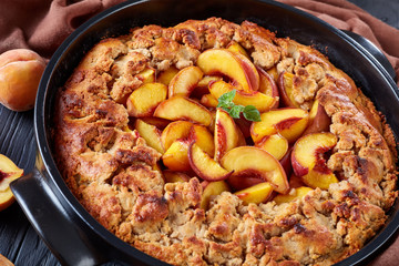 Oven baked Southern Peach Cobbler in a black dish