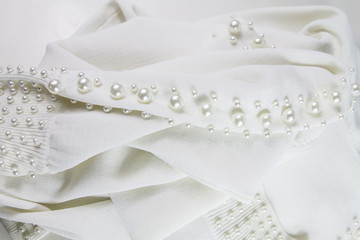 weißer Stoff mit Perlen bestickt