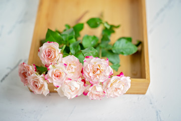 pink roses on a wooden tray