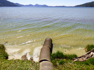 Open sewer going straight to Lagoa da Conceicao, famous lagoon and popular tourist destination in Florianopolis, Brazil