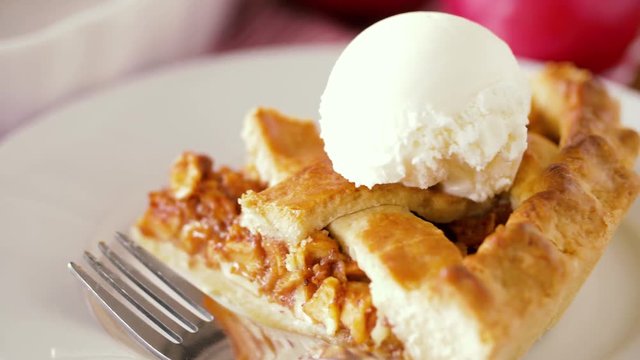 food, culinary and baking concept - close up of apple pie with vanilla ice cream and fork on plate
