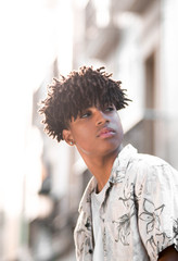 Hispanic black young man model with afro curly hair portrait hawagiian flower pattern shirt looking to the side